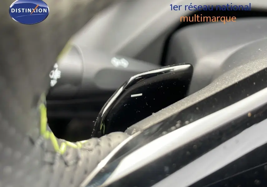Gros plan sur la palette de changement de vitesse au volant d’une Peugeot 308 gris selenium metal, intérieur noir.