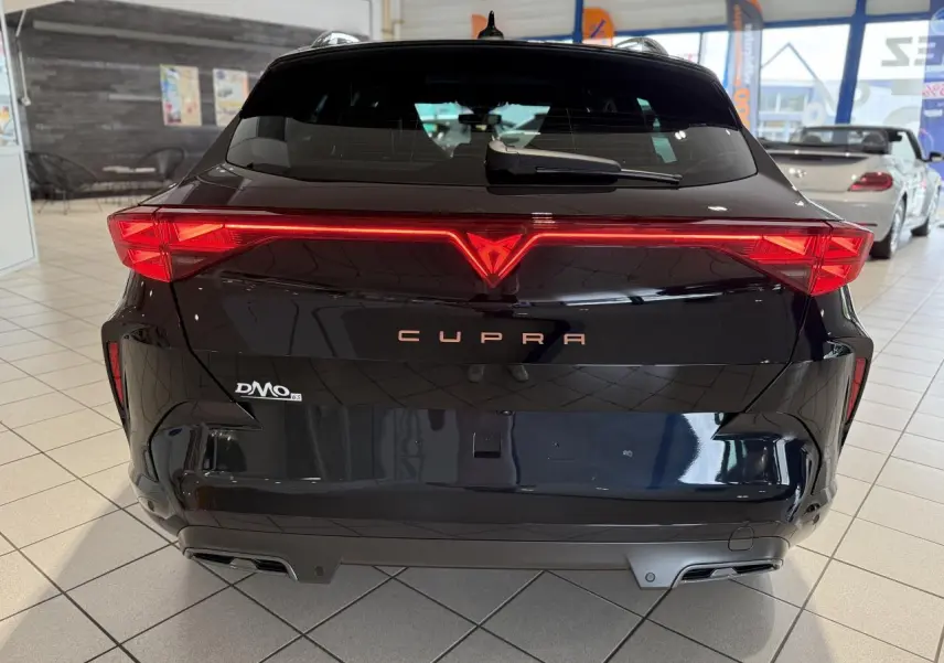 Vue arrière d'un CUPRA Formentor noir Night avec feux arrière en bandeau lumineux Tri-LED et double sortie d'échappement.