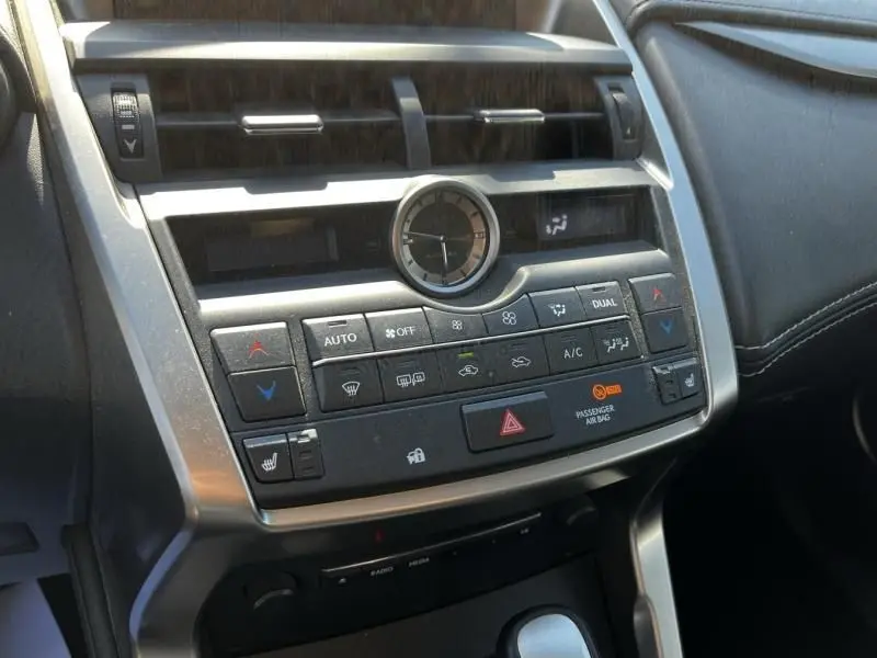 Vue rapprochée de la console centrale du Lexus NX 300H 2WD Sport Edition 2017, avec horloge analogique et commandes de climatisation.