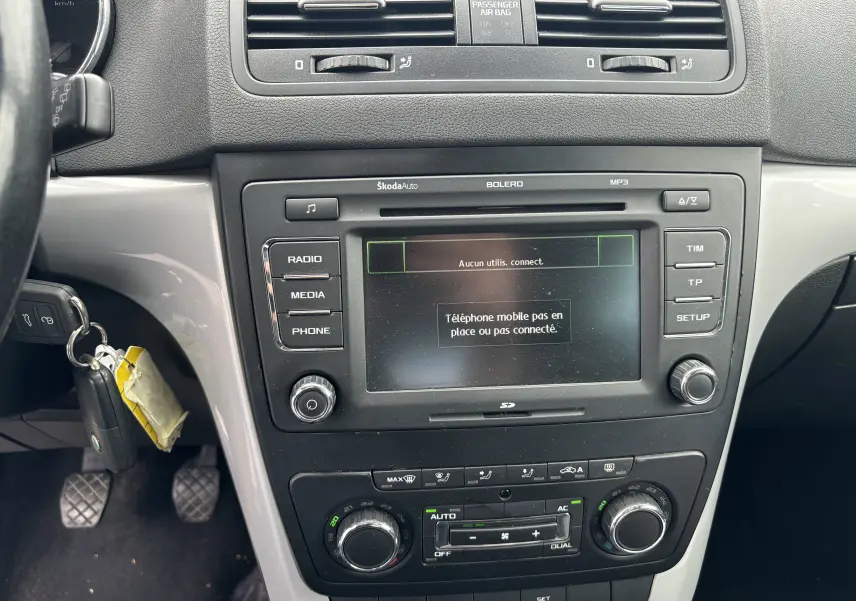 Vue intérieure centrée sur la console centrale grise du Skoda Yeti Ambition 2012 avec écran multimédia et commandes climatisation.