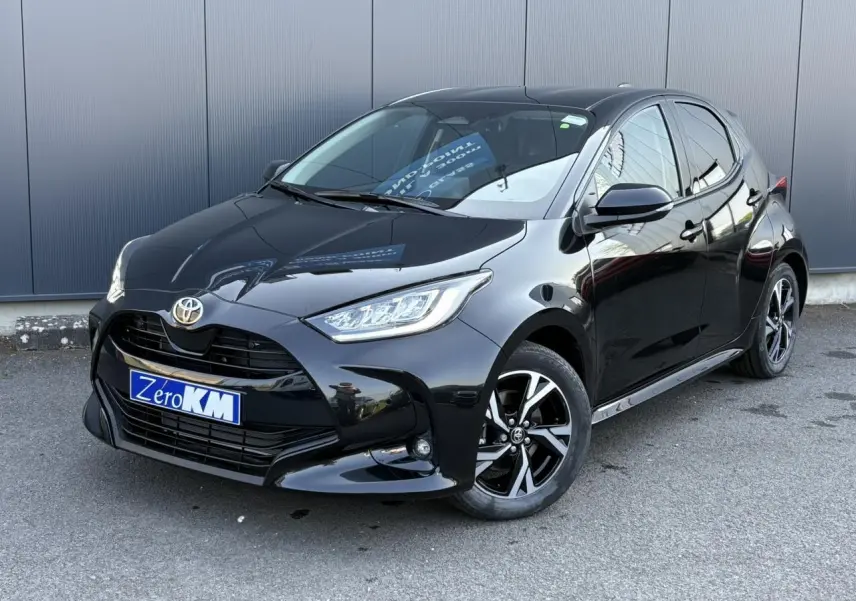 Toyota Yaris hybride noire vue en 3/4 avant droit avec jantes alliage et calandre noire brillante.