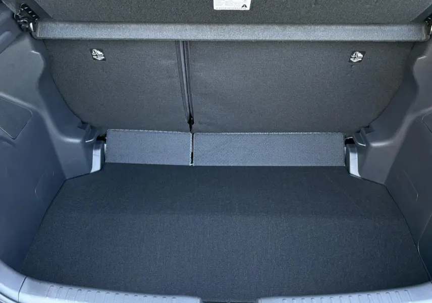 Coffre ouvert de la Toyota Yaris Hybride 2025, vue intérieure montrant un espace de chargement propre et noir.