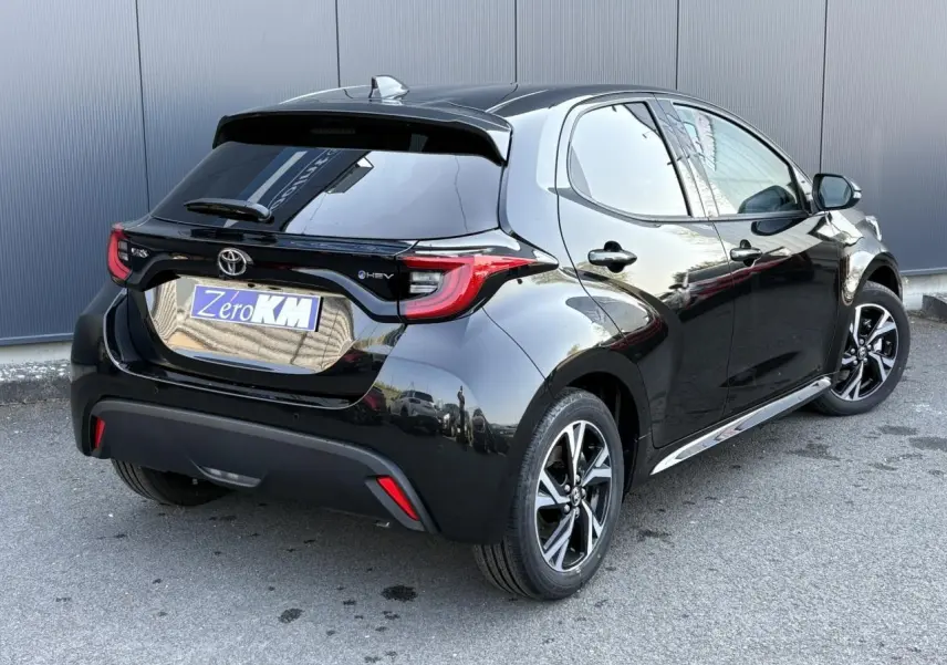 Toyota Yaris Hybride noire vue en 3/4 arrière droit, avec jantes alliage et feux arrière LED distinctifs.