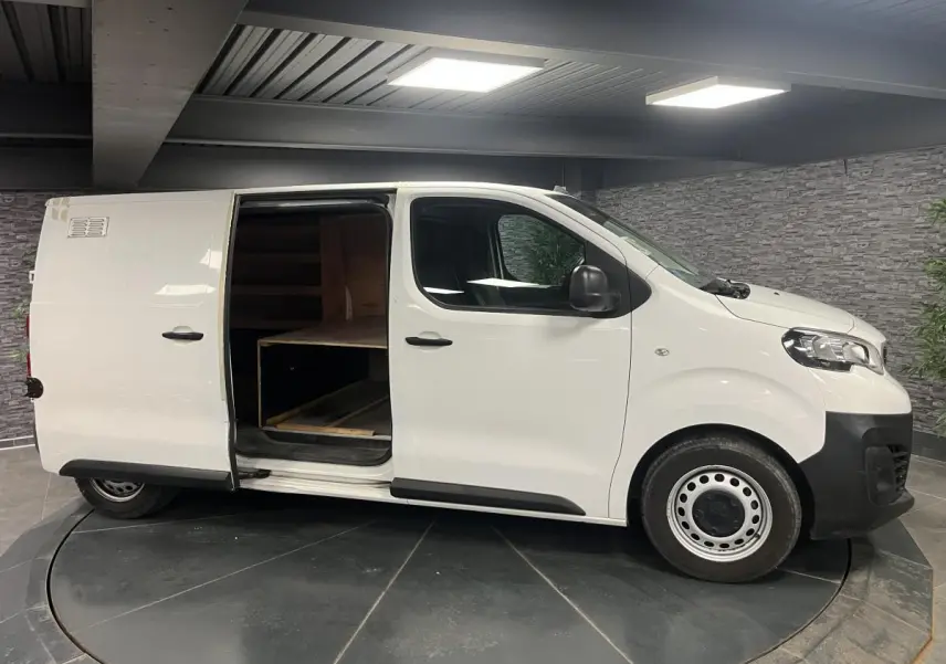 Peugeot Expert Fourgon blanc vu de profil droit, porte latérale coulissante ouverte montrant l'intérieur bois.