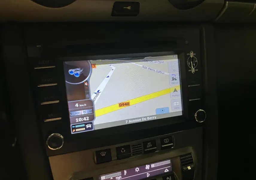 Écran de navigation PCM affichant une carte GPS dans le tableau de bord noir du Porsche Cayman 987 2008.