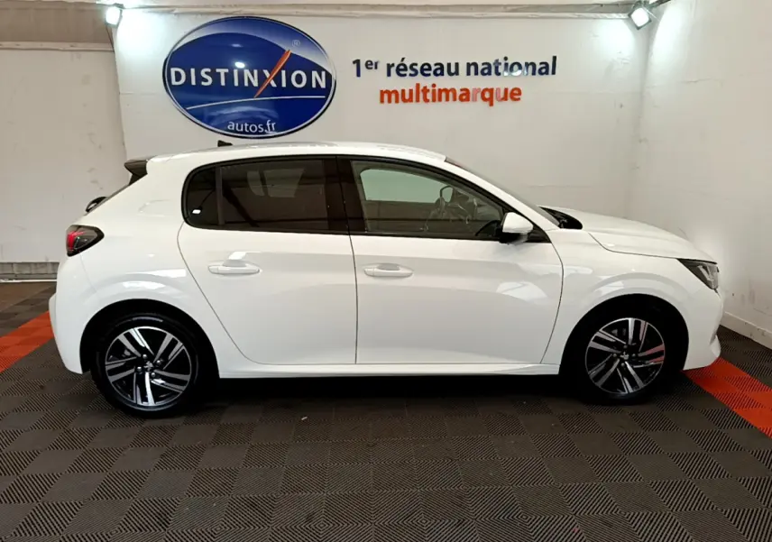 Profil côté gauche d'une Peugeot 208 blanche PureTech 100 S&S Allure Business, en intérieur sur sol damier noir et rouge.