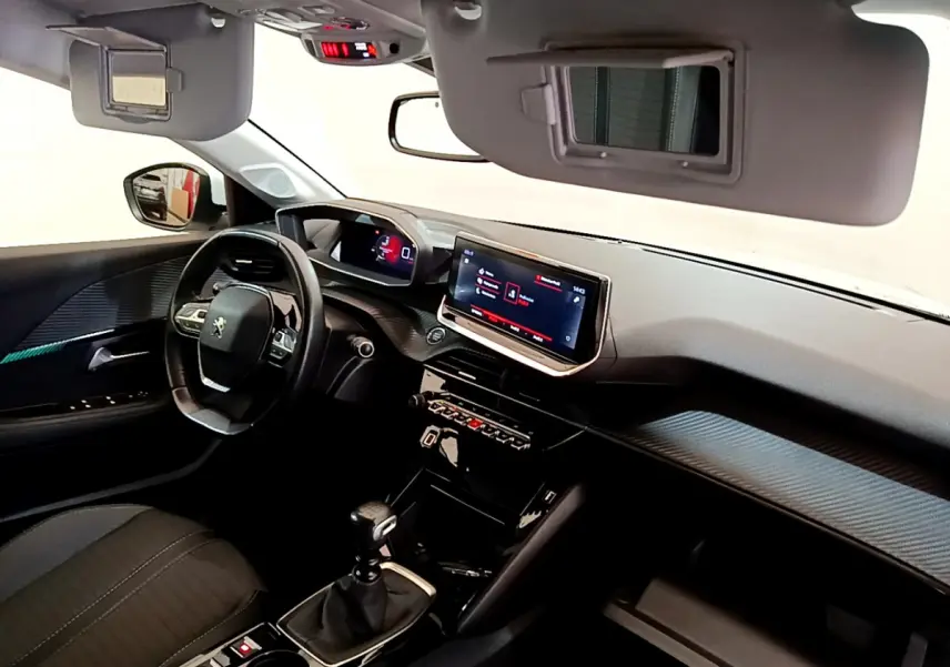 Intérieur noir de la Peugeot 208 PureTech 100, vue côté conducteur sur tableau de bord et écran tactile central.