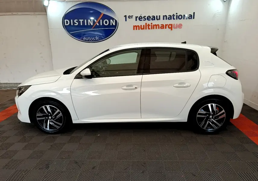 Profil côté gauche d'une Peugeot 208 blanche PureTech 100 S&S Allure Business, en intérieur sur sol damier noir et rouge.