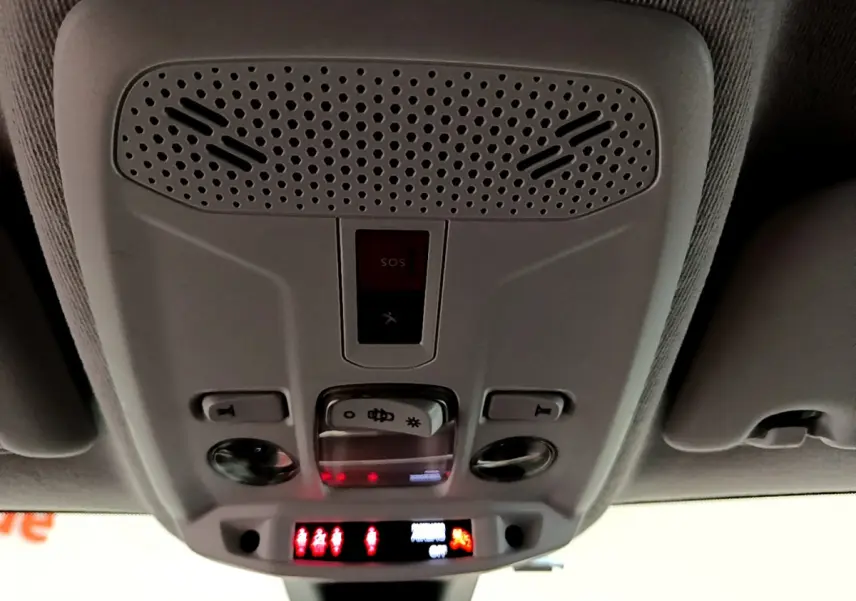 Vue en contre-plongée du plafonnier gris clair avec commandes d’éclairage et bouton SOS du Peugeot 208 blanc PureTech 2020