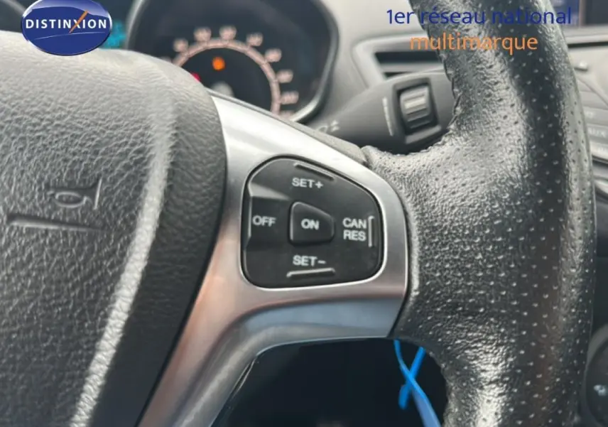 Gros plan sur le volant noir de la Ford Fiesta 2017 avec commandes de régulateur de vitesse visibles.