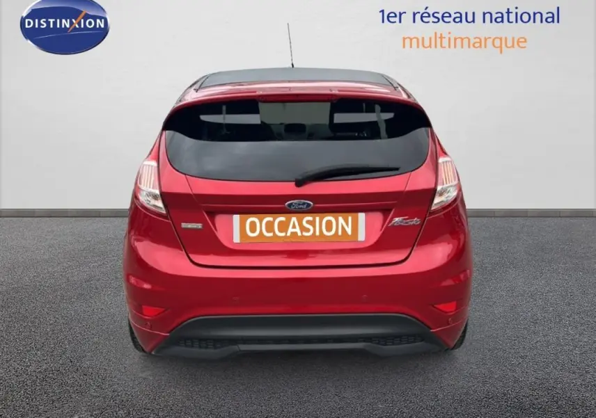 Vue arrière d'une Ford Fiesta rouge 2017 avec vitres surteintées et logo "Occasion" sur le coffre.
