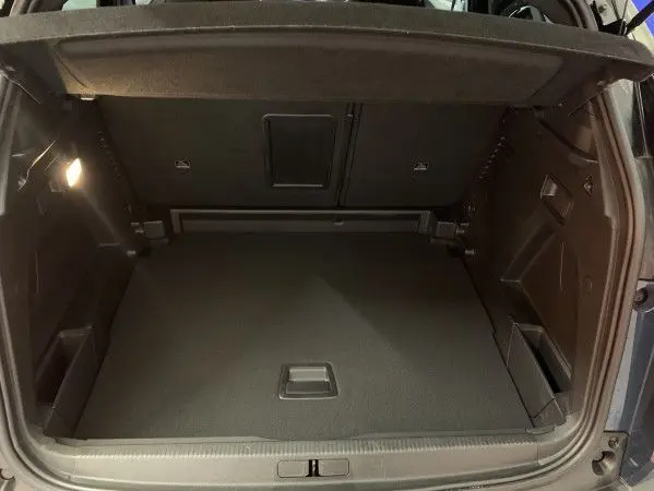 Coffre ouvert vu de l'arrière d'un Peugeot 3008 Bleu Célèbes, montrant un espace de chargement propre et spacieux.