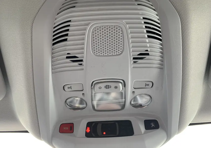 Vue en gros plan du plafonnier intérieur gris clair du Peugeot 3008 avec boutons d’éclairage et alerte SOS.