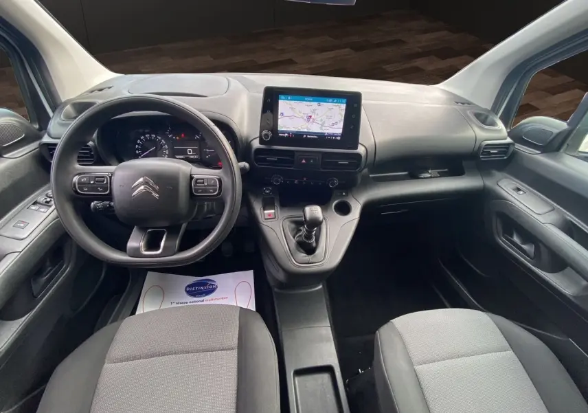Vue intérieure du poste de conduite du Citroën Berlingo blanc 2019, avec tableau de bord et écran tactile central.