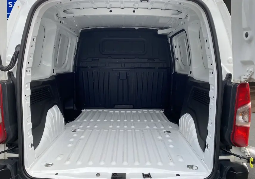 Vue arrière du fourgon Citroën Berlingo blanc 2019, montrant l'espace de chargement vide avec parois noires.
