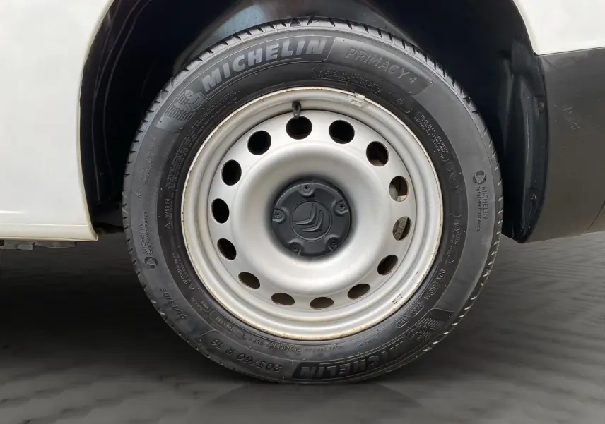 Gros plan sur la roue avant gauche d'un Citroën Berlingo blanc de 2019, avec jante acier et pneu Michelin.