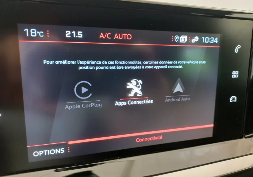 Écran tactile central de la Peugeot 208 blanche PureTech 100 S&S Allure affichant les options Apple CarPlay et Android Auto.