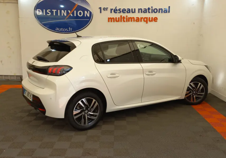 Vue côté droit arrière d'une Peugeot 208 blanche PureTech 100 S&S Allure avec feux LED et jantes alliage modernes.