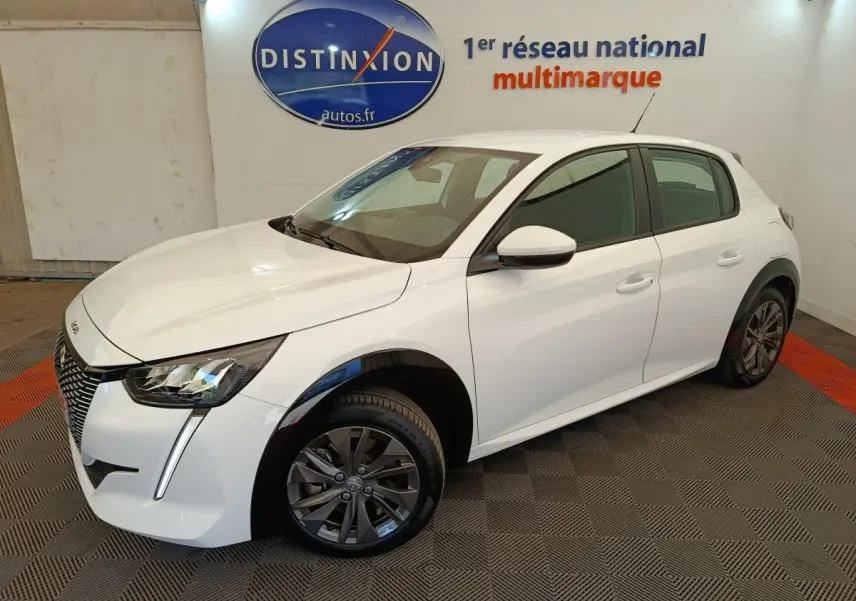 Peugeot 208 électrique blanche vue 3/4 avant droit, avec phares LED et jantes alliage gris foncé.