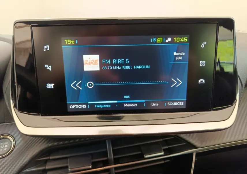 Écran tactile central de la Peugeot 208 électrique Active Business R affichant une radio FM, vue intérieure frontale.