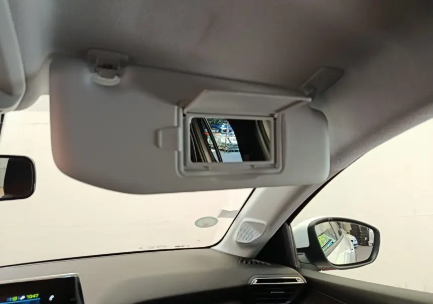 Intérieur de la Peugeot 208 électrique blanc, vue sur pare-soleil avec miroir et rétroviseur côté droit.