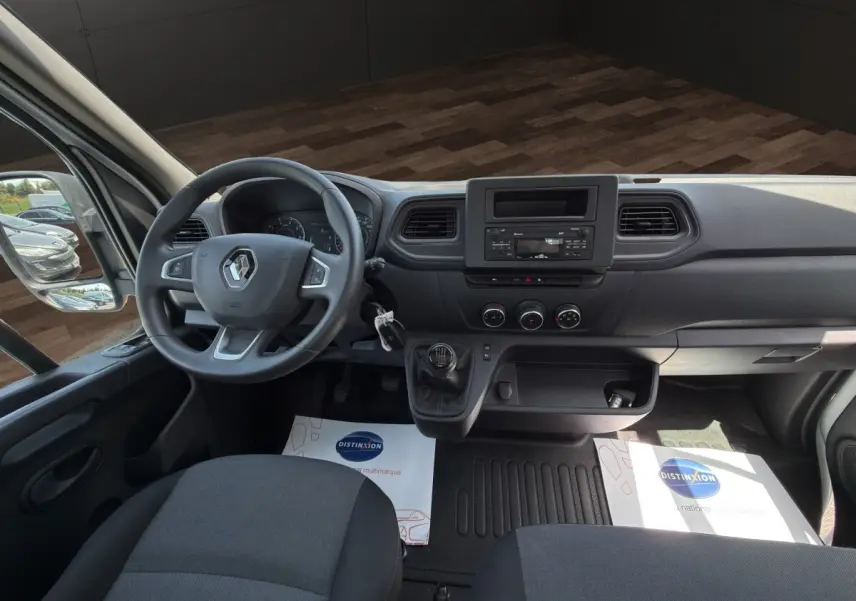 Vue intérieure avant du Renault Master 2024, montrant le volant, tableau de bord noir et levier de vitesse manuel.