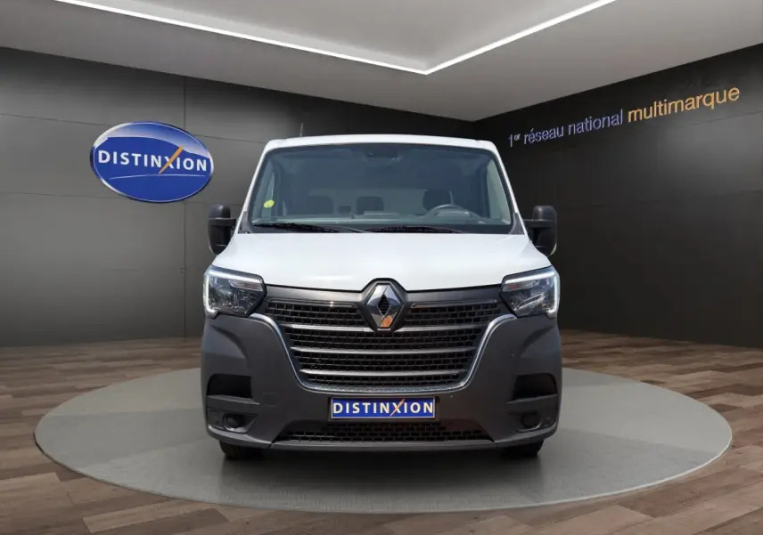 Renault Master blanc vu de face, avec calandre noire proéminente et phares modernes à LED dans un showroom.