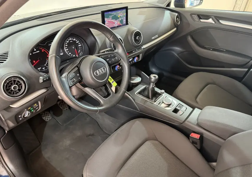 Intérieur de l'Audi A3 2.0 TDI 150 Business Line 2018 vu côté conducteur, volant cuir et écran navigation visible.