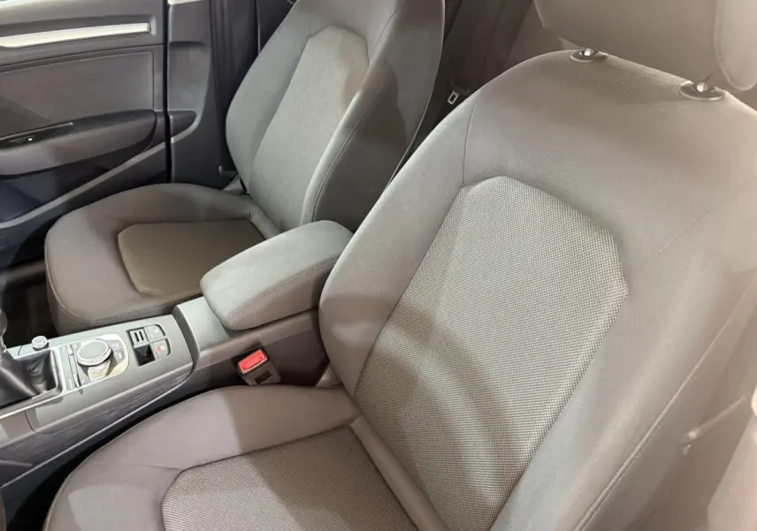 Vue intérieure rapprochée des sièges avant gris foncé et de la console centrale d'une Audi A3 2.0 TDI 2018.