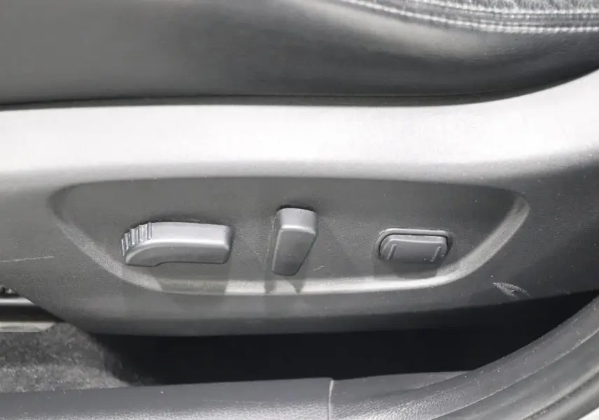 Gros plan sur les commandes de réglage électrique du siège conducteur en cuir noir du Nissan X-TRAIL 2021.