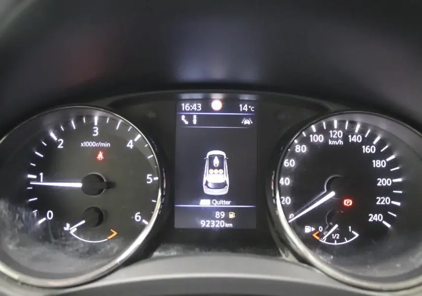 Vue rapprochée du tableau de bord du Nissan X-Trail 1.7 D gris, affichant 92 320 km et jauge carburant presque vide.