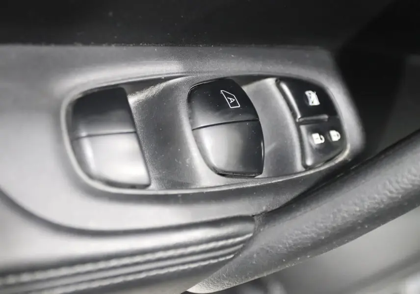 Gros plan sur les commandes de lève-vitres et verrouillage sur la porte intérieure côté conducteur du Nissan X-TRAIL 2021.