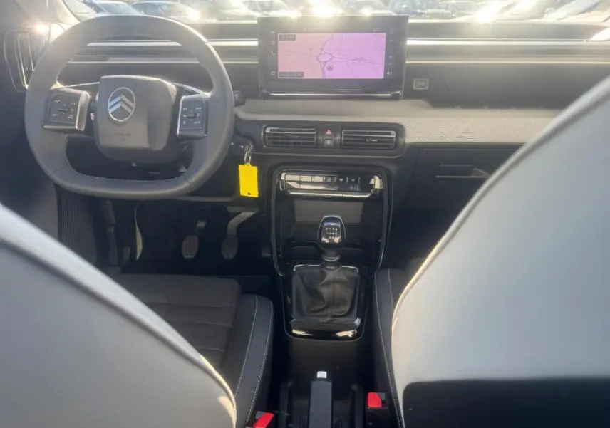 Vue intérieure avant de la Citroën C3 gris 2025, volant multifonction, écran tactile et levier de vitesse manuel visible.