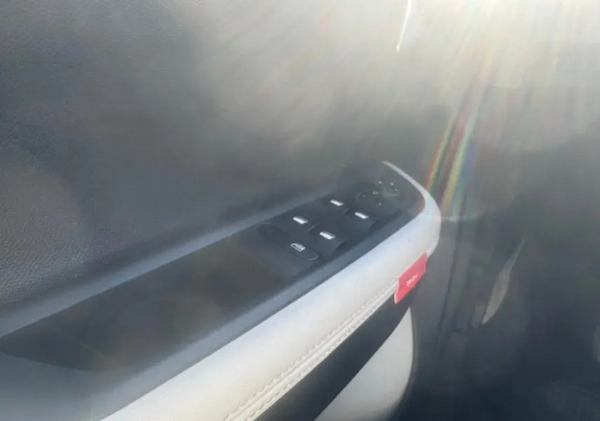 Gros plan sur la commande des vitres électriques côté conducteur d'une Citroën C3 gris 2025, avec bouton de verrouillage visible.