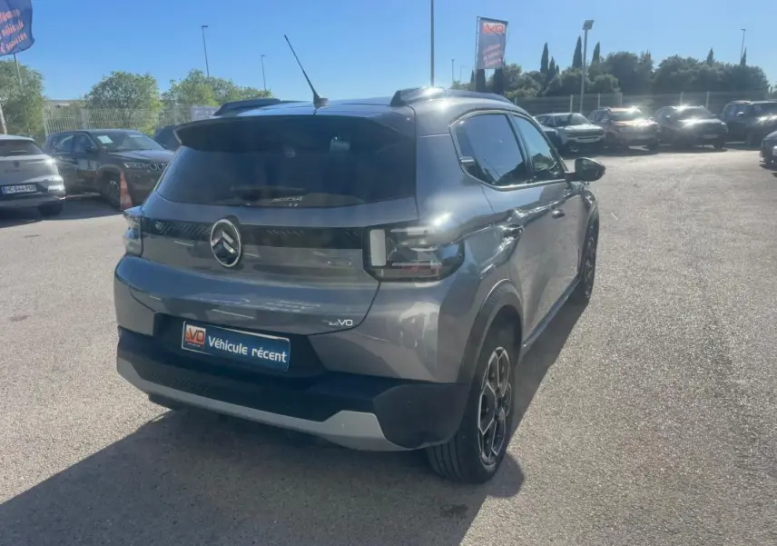 Vue 3/4 arrière droite d'une Citroën C3 Turbo 100 ch gris avec jantes alliage 17 pouces et barres de toit visibles.