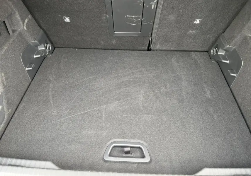 Vue intérieure du coffre spacieux et propre de la Citroën C4 Hybrid 2025, avec revêtement noir uniforme.