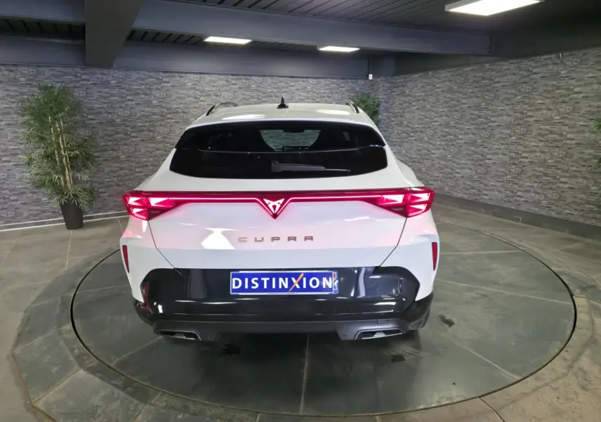Vue arrière d'une CUPRA Formentor blanche 2025 avec feux arrière en bandeau lumineux Tri-LED et diffuseur noir contrastant.