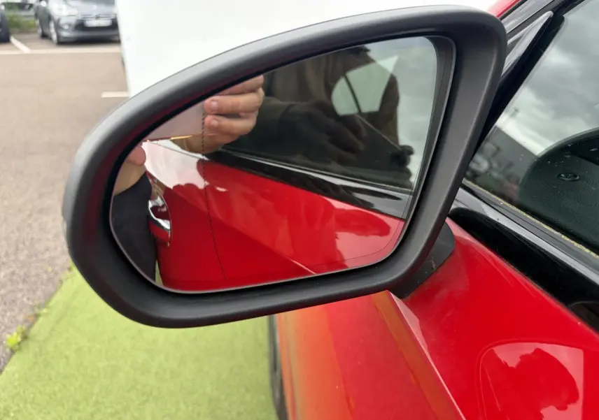Rétroviseur extérieur côté gauche d’une Mercedes Classe A rouge, avec carrosserie brillante et contours noirs.