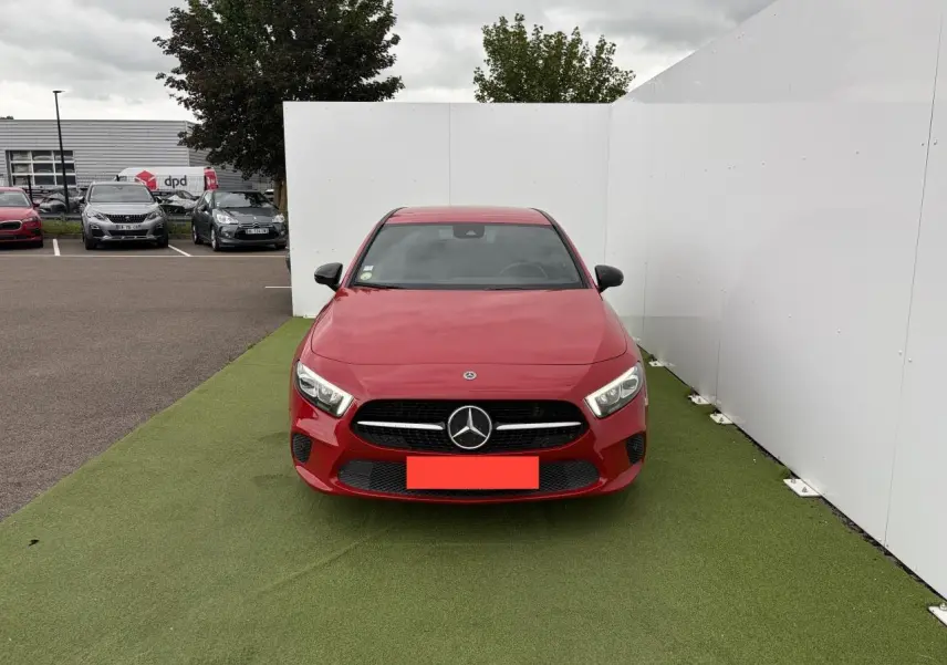 Vue avant d'une Mercedes Classe A IV 180 d Progressive Line rouge, avec calandre diamant et logo central visible.