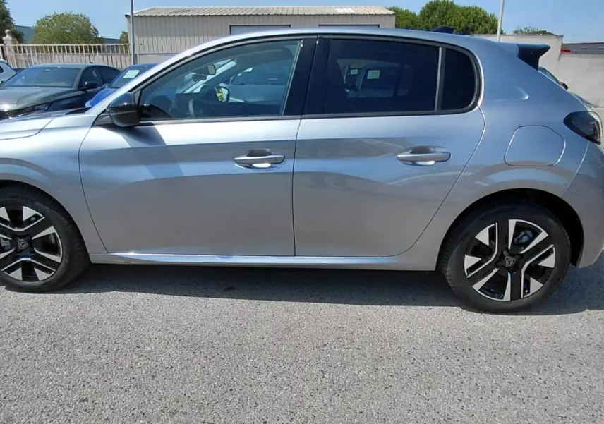 Peugeot 208 Hybrid gris vue de profil côté gauche, avec jantes alliage noires et argentées visibles.