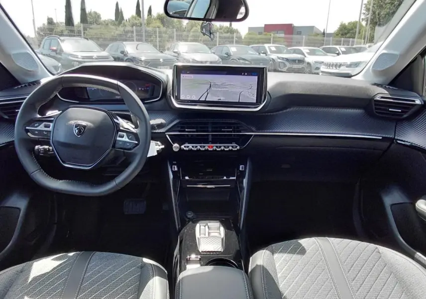 Intérieur de la Peugeot 208 gris, vue de face sur le tableau de bord avec écran tactile et volant multifonction.
