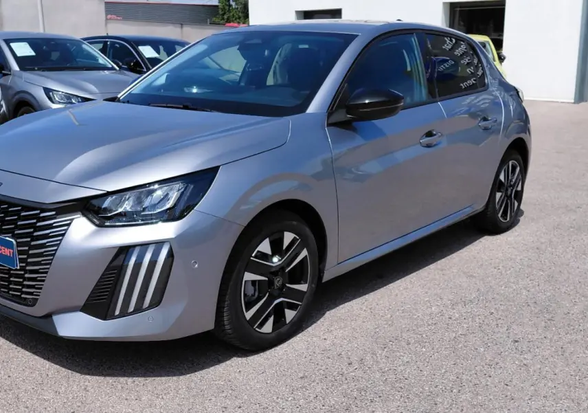 Peugeot 208 Hybrid gris vue 3/4 avant droit, avec calandre distinctive et jantes alliage 16 pouces.
