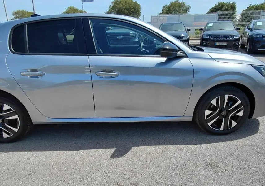 Peugeot 208 gris vue de profil côté gauche, avec jantes alliage noires et vitres teintées.