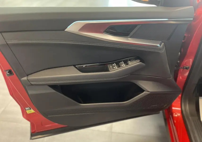 Vue rapprochée de la porte avant gauche rouge du Renault Rafale 2025, avec commandes de vitres et garniture noire.