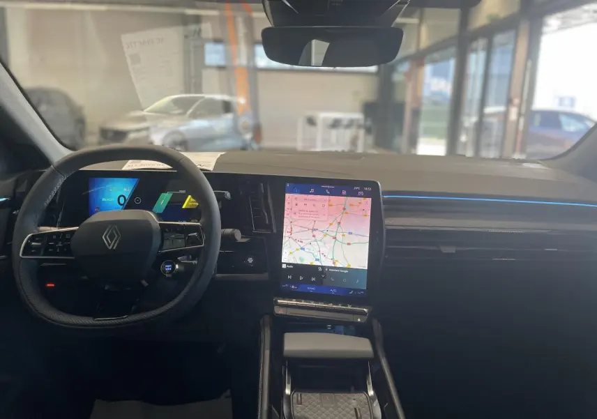Vue intérieure avant du Renault Rafale 2025, tableau de bord avec écran tactile central et volant multifonctions noir.