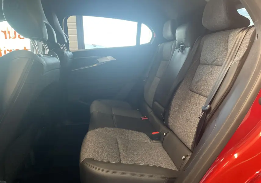 Vue latérale intérieure montrant la banquette arrière bi-matière gris clair et noir dans une Renault Rafale rouge.