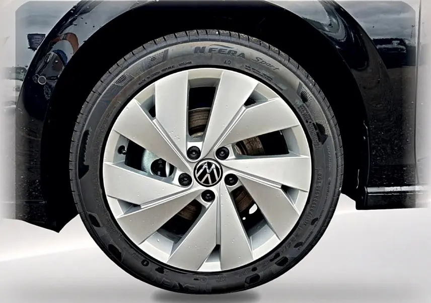 Gros plan sur la roue avant droite noire d'une Volkswagen Golf 2026 avec jante alu 17 pouces argentée.