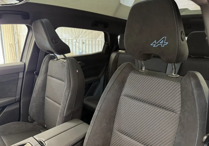 Intérieur du Renault Espace esprit Alpine 2025, vue côté droit sur sièges en suède gris foncé avec logo Alpine brodé.