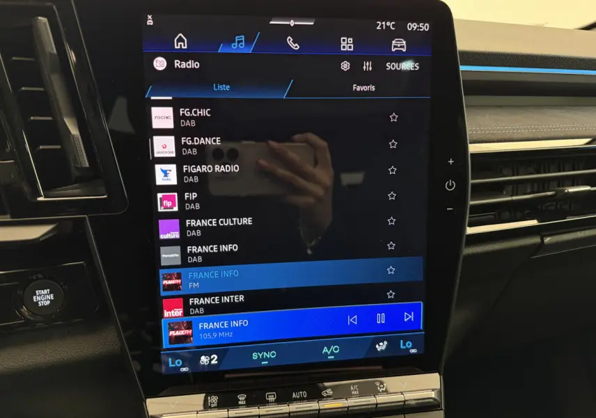 Écran tactile central du tableau de bord du Renault Espace gris foncé, affichant les stations radio DAB et FM.