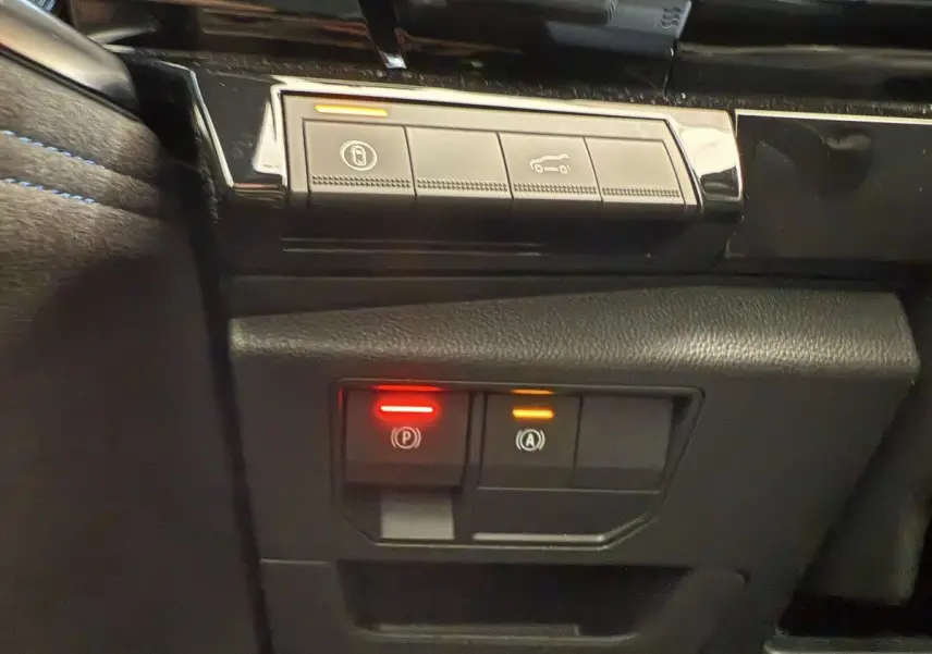 Gros plan sur les commandes de frein de stationnement et démarrage automatique dans l'habitacle noir du Renault Espace esprit Alpine 2025.